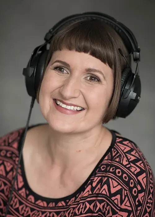 Stephanie Cannon wearing headphones and smiling broadly